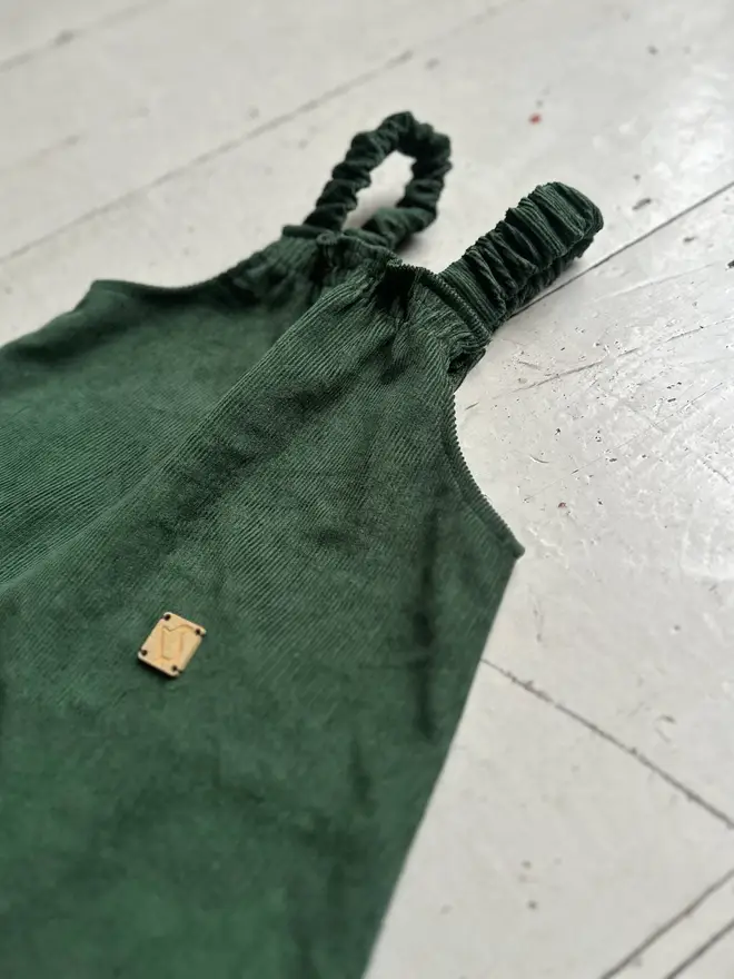 close up front elastic of kids organic cotton needlecord dungarees dark green