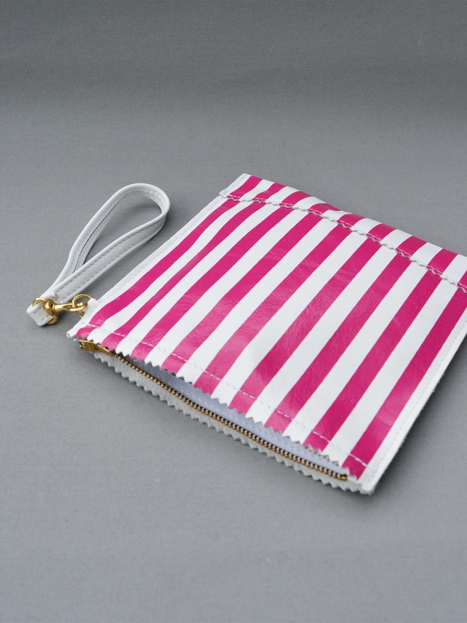 ykk metal zip closure on a pink and white striped paper bag made in leather by Natthakur