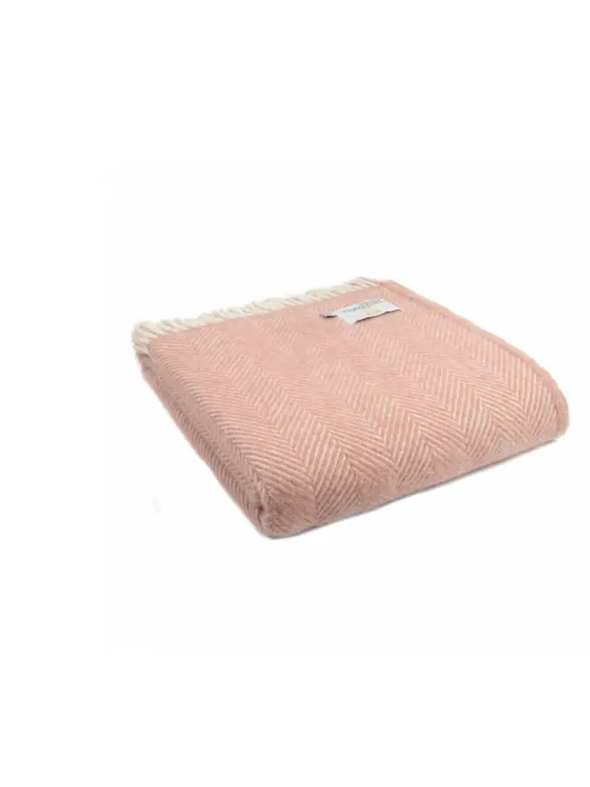 Lambswool dusty pink throw folded on a white back ground. 
