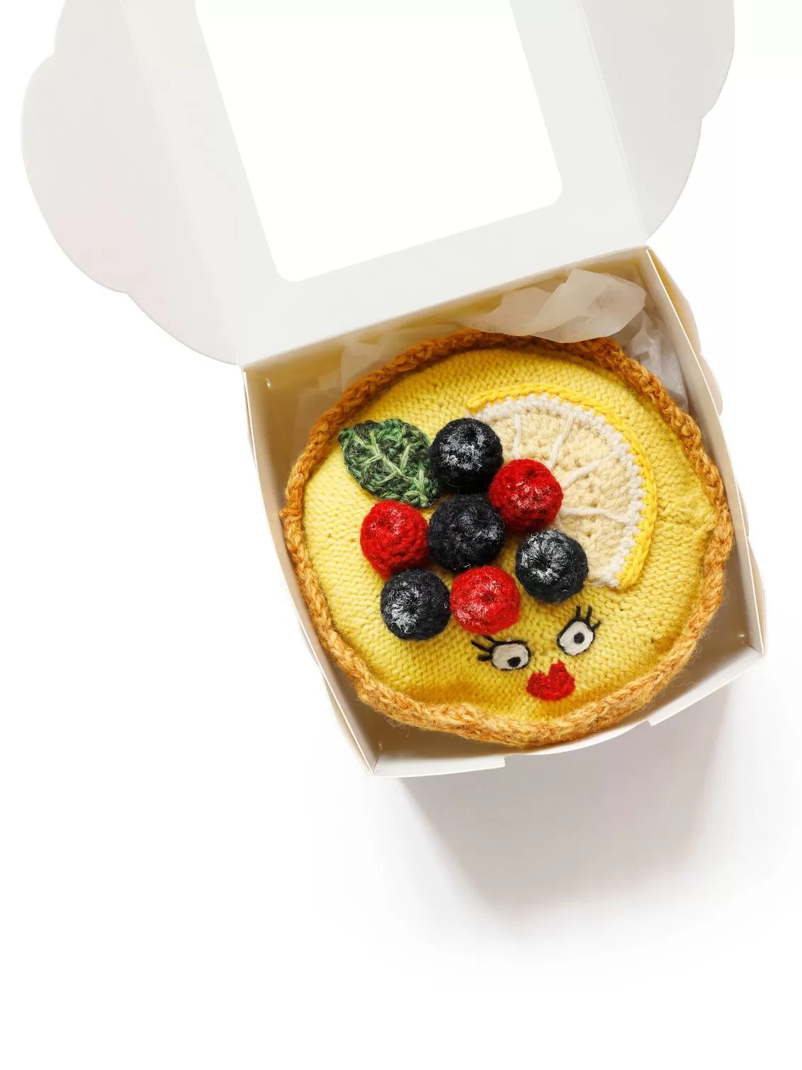 Kate Jenkins hand embroidered and crotched Lemon Tart with blueberries and rasberries on top. Seen nestled in a cake box with tissue paper.