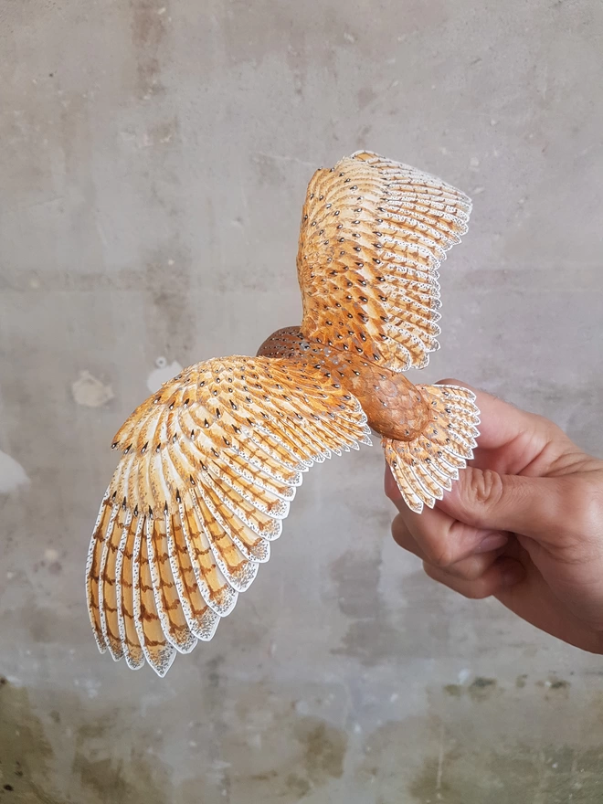 Handmade paper barn owl sculpture in artists hand
