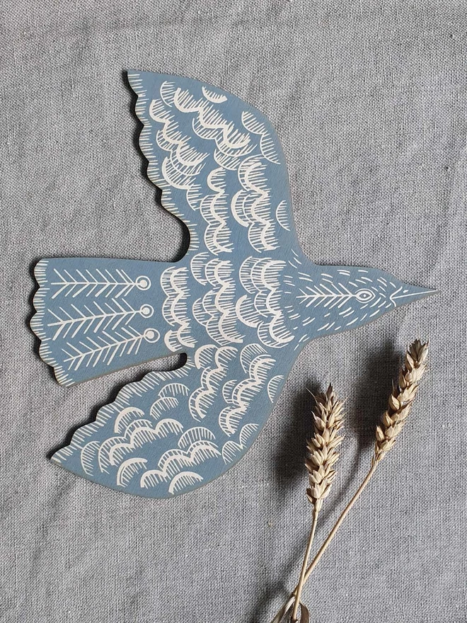 Wall mounted wooden hand printed bird decoration in blue grey. 