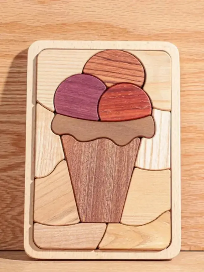 Sweet Scoops Wooden Persistence Jigsaw Puzzle Heirloom Toy, against a wooden background. 
