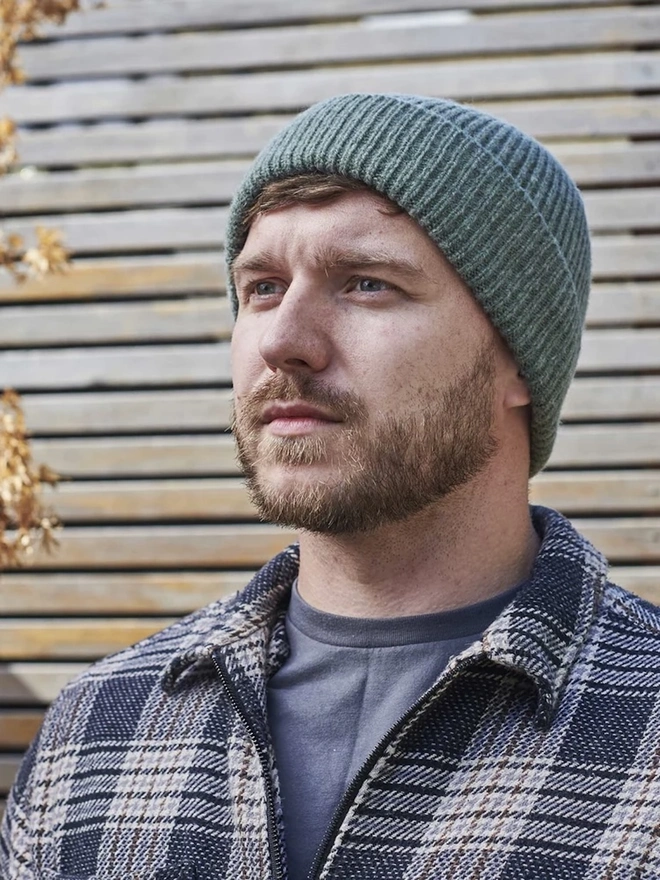 Ribbed Lambswool Men's Beanie, a person wearing a colourful ribbed beanie outdoors. 