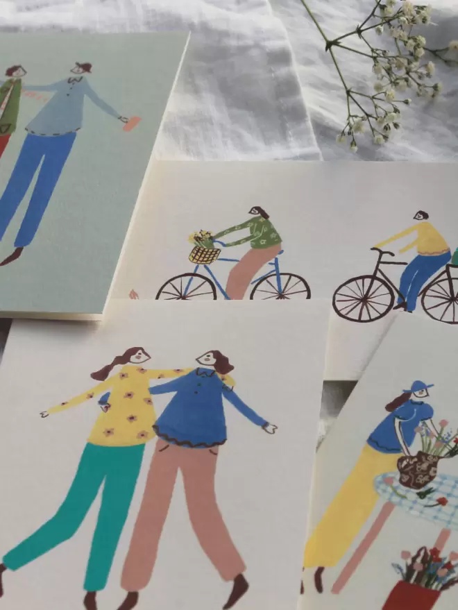 cluster of greetings cards with people and bikes on with flowers 