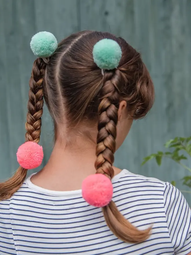 pom pom hair bobble elastics in young girl's hair
