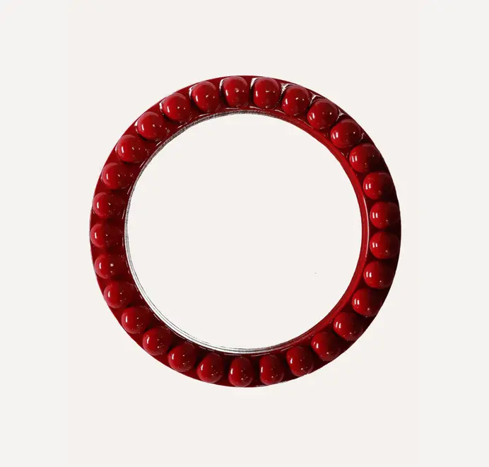 Round oversized bobbin mirror with a decorative bobbin-style wooden frame, hanging on a white wall.