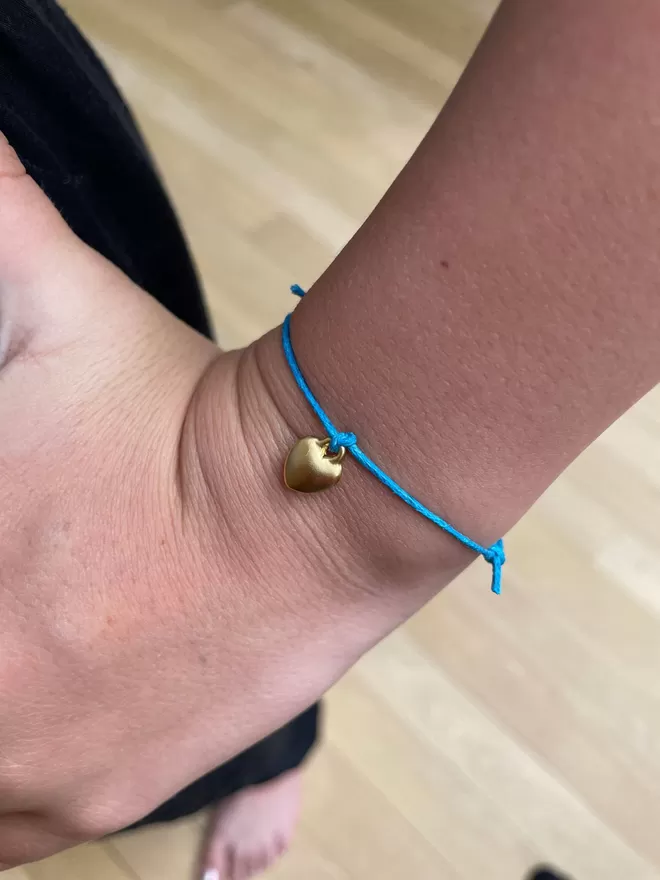 Close up of wish bracelet on a girls wrist.