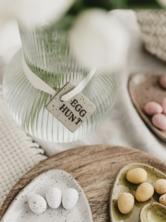 ceramic egg hunt tag tied around a glass vase