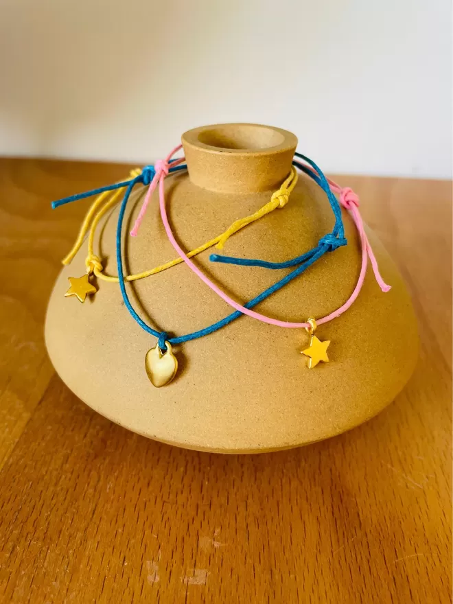 Three wish bracelets on a clay pot.