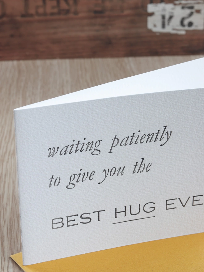 close up of letter pressed text 'waiting patiently to give you the best hug ever' 
