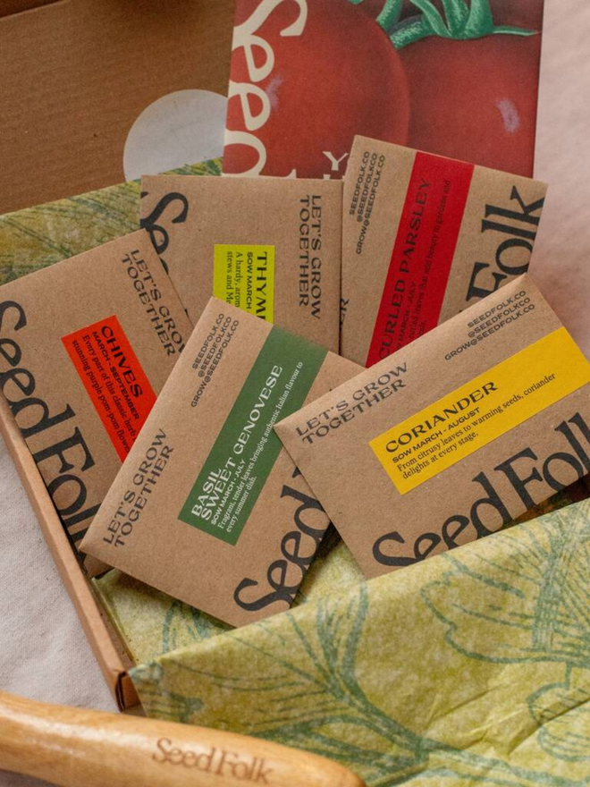 the herb garden seed collection. packaging for seed packets decorated with illustrated green leaf outlines. box open to show seed packets inside.
