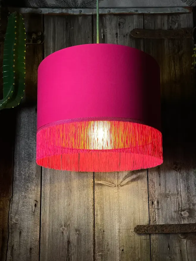 Pomegranate Pink Lampshade With Gold Lining & Pink Fringing, hanging. 