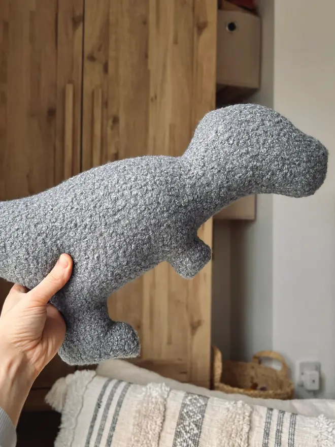 boucle dinosaur pillows. a grey t-rex cushion.