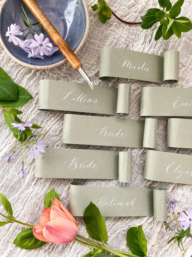 sage green scroll calligraphy wedding place cards. sage green scroll with white calligraphy.
