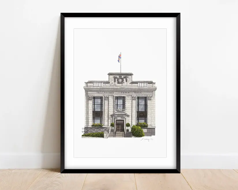 Islington Town Hall Giclée Print (Unframed), a print of a town hall sitting in a black frame on a wooden surface against a plain backdrop. 