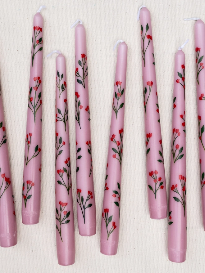 Pink taper candles hand painted with wildflower blossoms. 