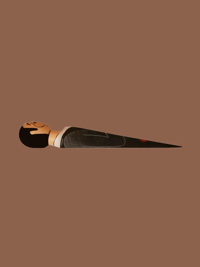 Wooden Door Stopper (Salvadoor), a colourful wooden door stop sitting on a brown surface. 
