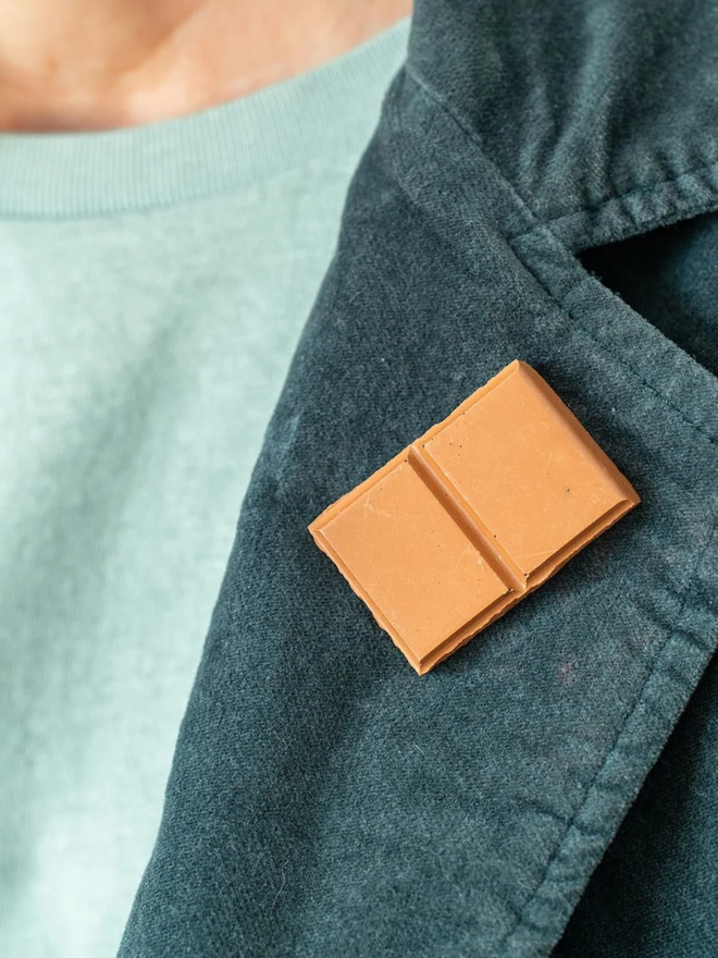 chocolate pin badges. a milk chocolate badge on a coat lapel.