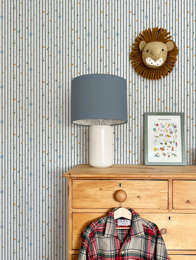 Ducks In A Row Stars and Stripes Wallpaper in Boys bedroom with lion head, drawers and lamp