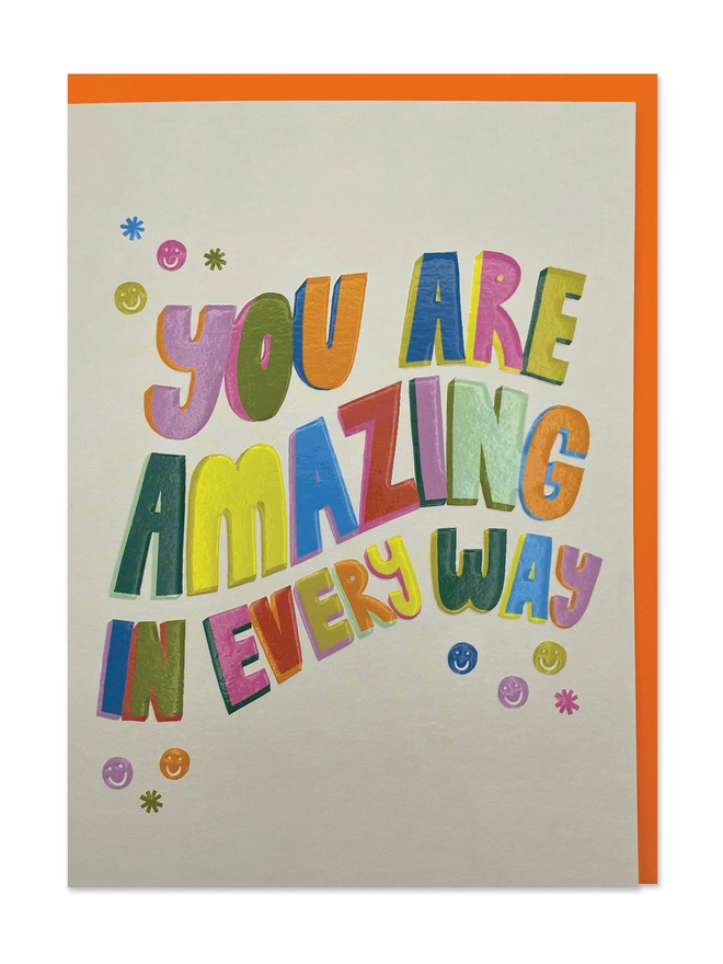 A colourful card with bold rainbow type ‘You are amazing in every way’ message on a cream background