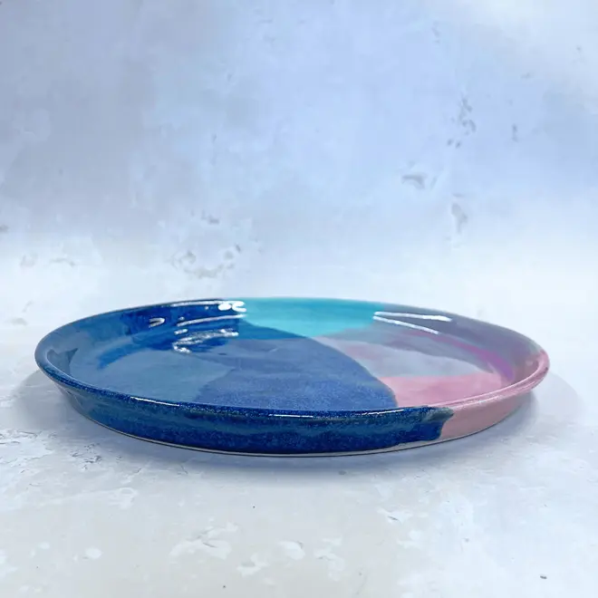 Landscape Dinner Plate, a colourful plate placed on a stone surface. 