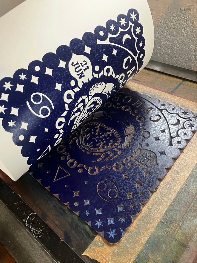 cancer zodiac linocut. a crab linocut and printed on a blue background.