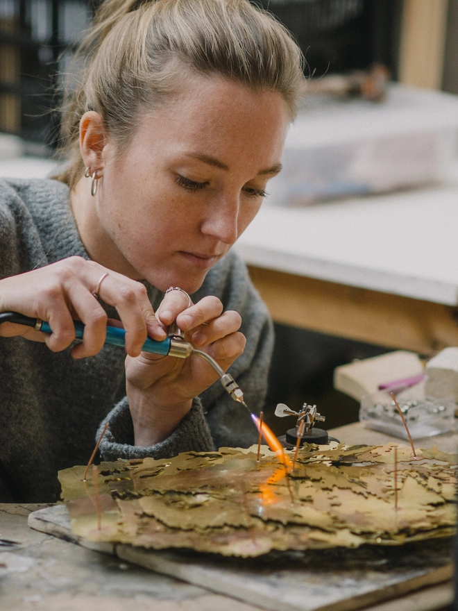 Soldering on the copper 'legs' onto the back of the metal map