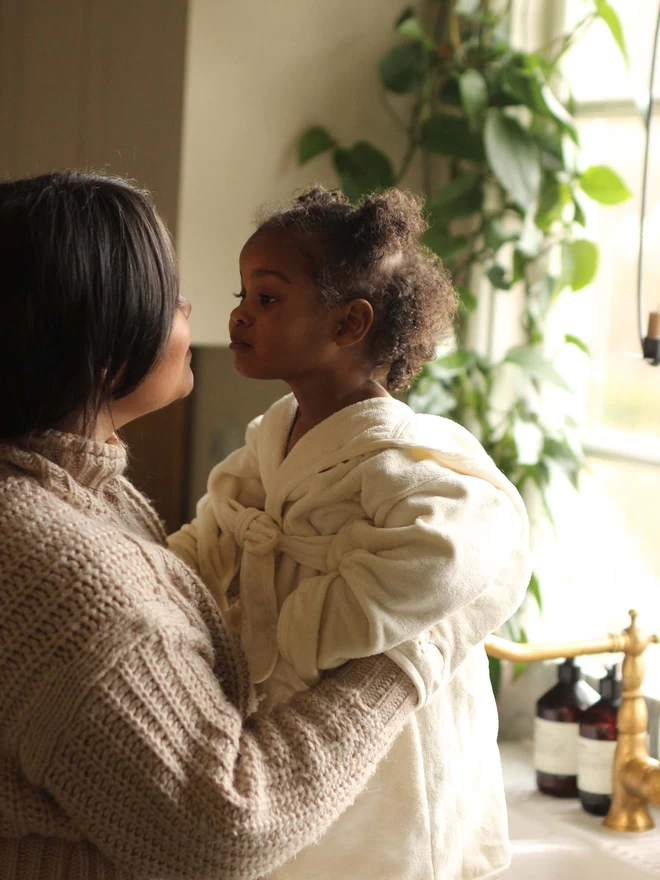 A mom dressing her baby with a towelling robe