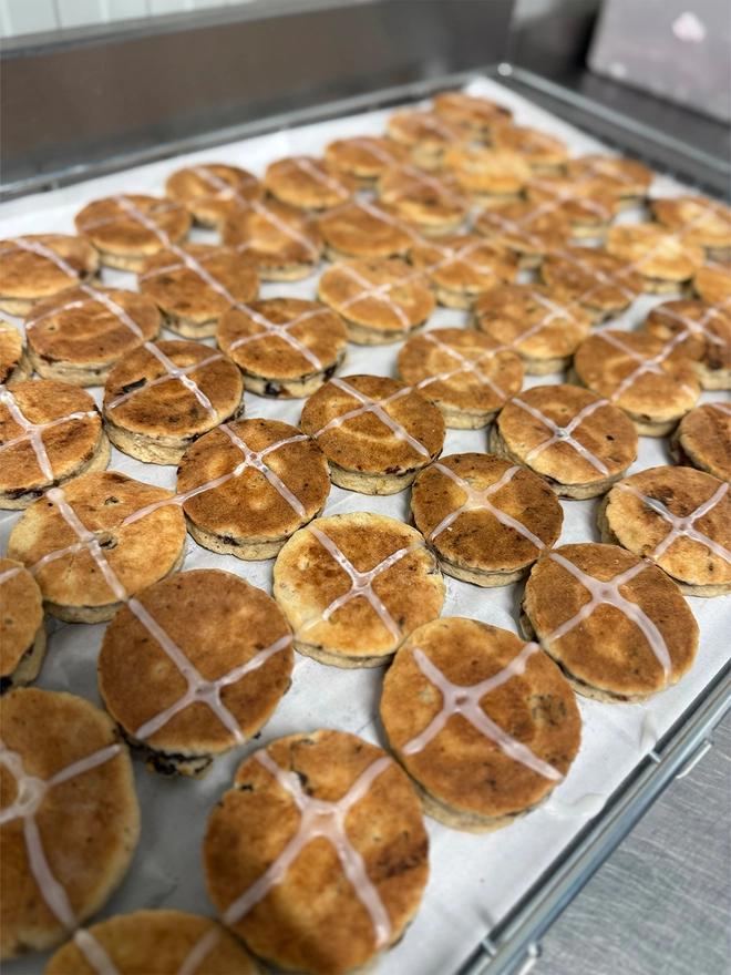 Lots of Hot Cross Bun Welsh Cakes on a cooling rack in the MamGu Welshcakes bakery