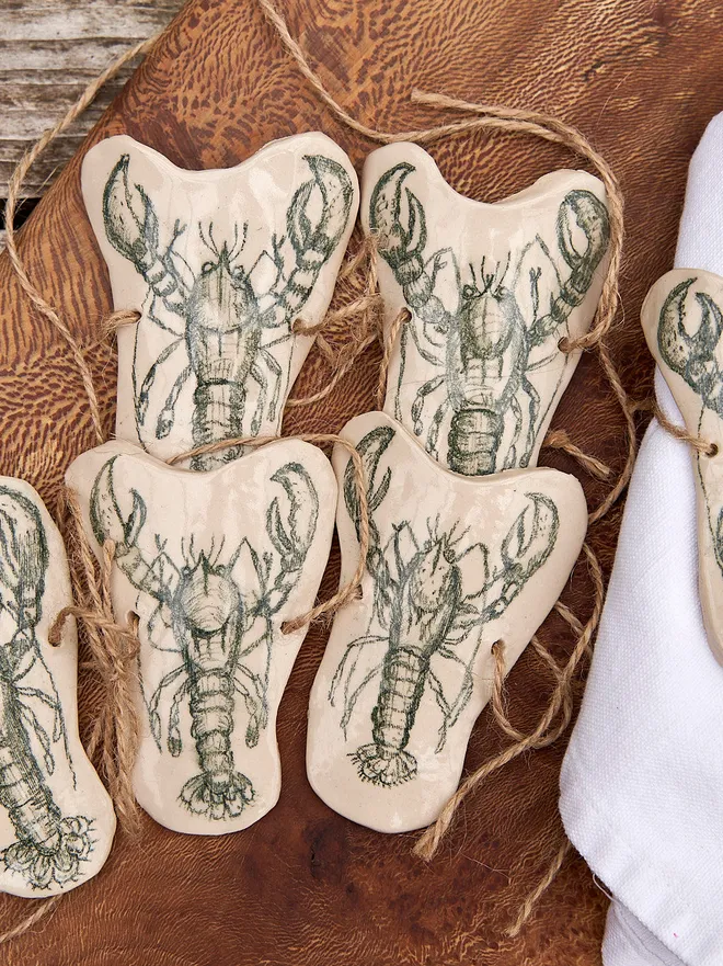 Ceramic Lobster Napkin Ring Holder, a ceramic lobster napkin sitting on a wooden chopping board. 
