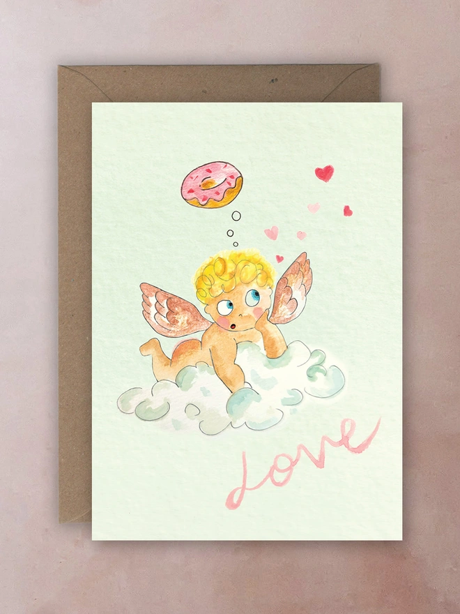 A cherub riding a cloud dreaming of doughnuts. the test reads love.