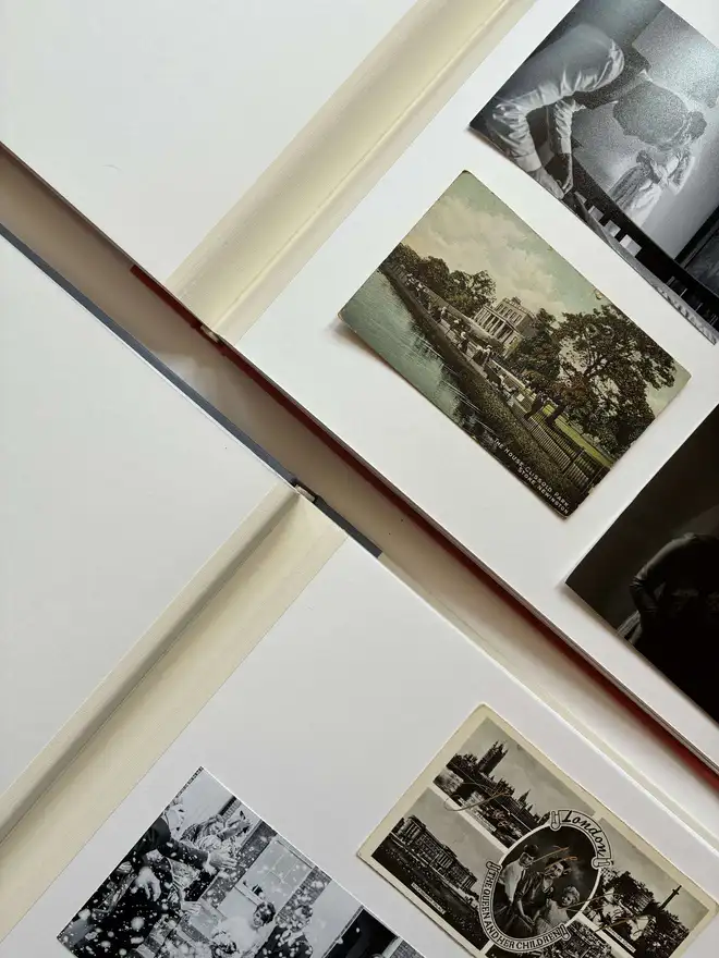 two open handmade photograph albums with cloth jointed pages