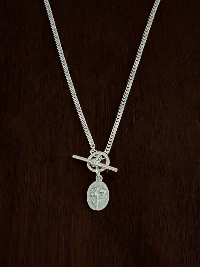 Forget me not medal charm on a curb t-bar necklace chain