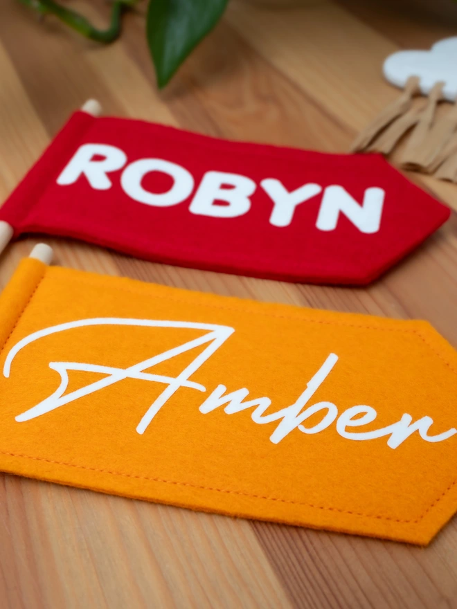 personalised hand held flags in red and orange felt with white lettering