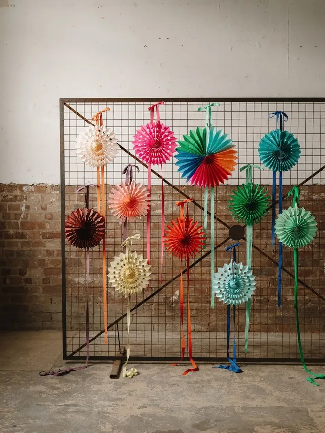 Colourful Paper fans hanging on a metal frame