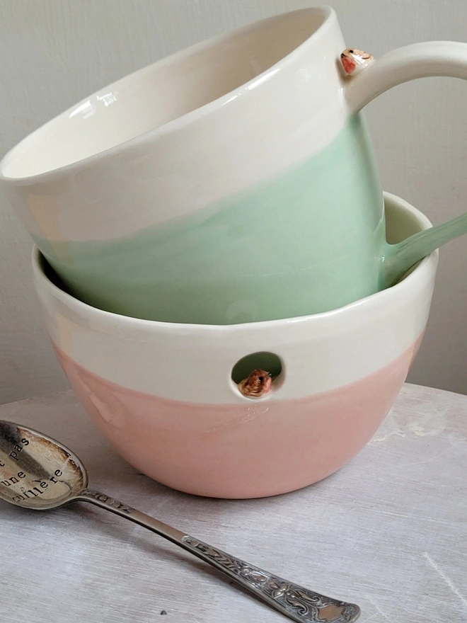 ceramic green mug with tiny rose robin bird on the handle and birdprints sitting in a pink ceramic bowl with robin red breast bird