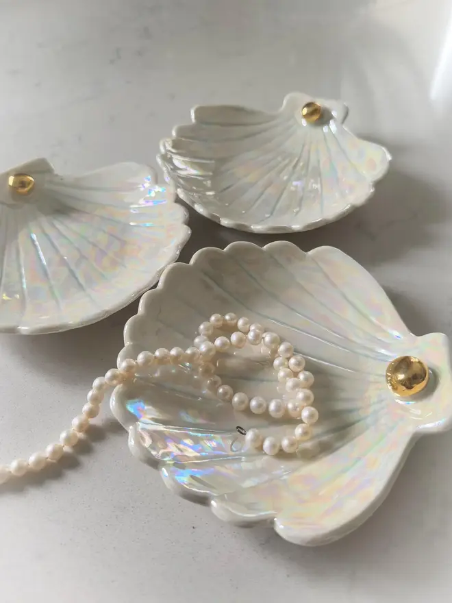 Handmade Porcelain Sea Shell Trinket Dish, in a trio positioned on a table with jewellery. 