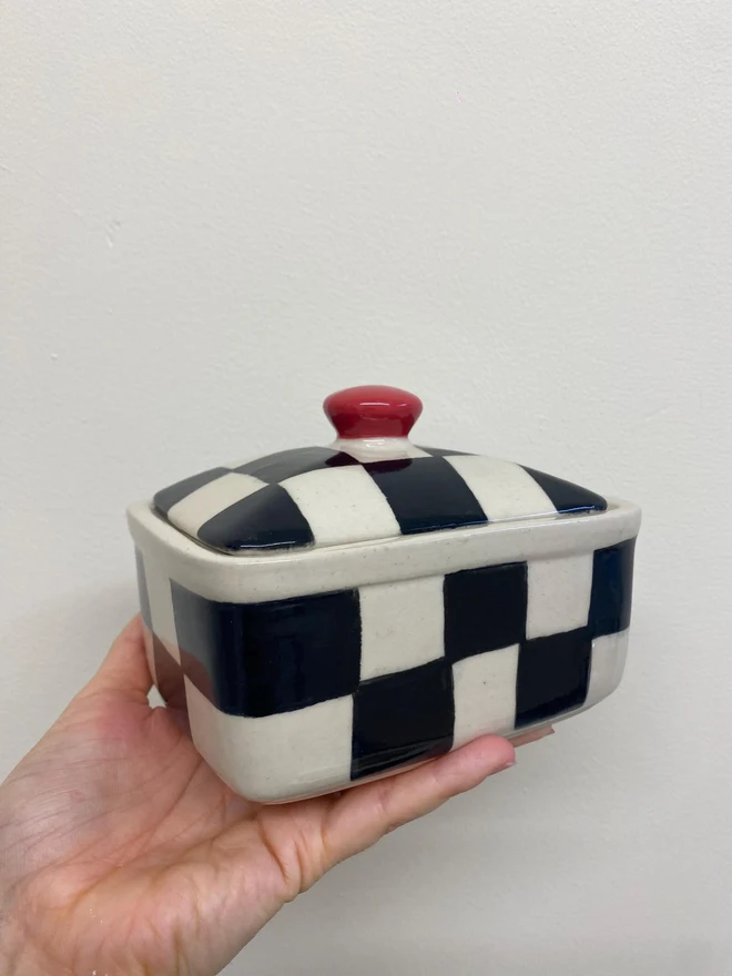  Checkered Black & Cream Handmade Ceramic Butter Dish, a black and white butter dish held against a white backdrop. 