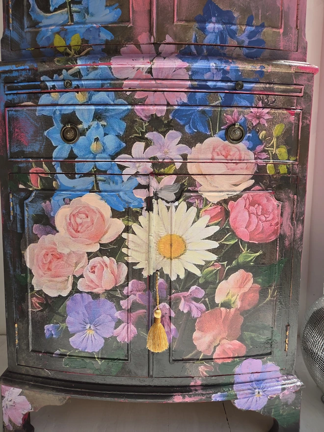 Close up of painted vintage wooden cabinet with pink, blue and floral decoration