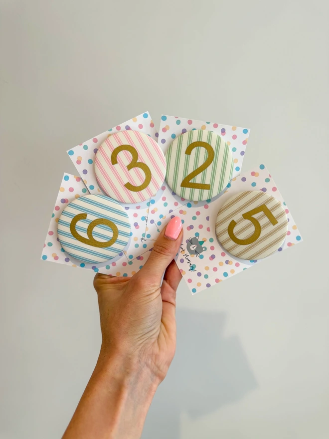 Ticking Stripe number birthday badges in pink, blue, beige and green