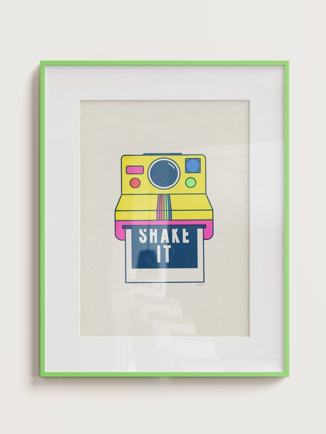 Framed screen print of a poloroid camera with the words Shake It on the image