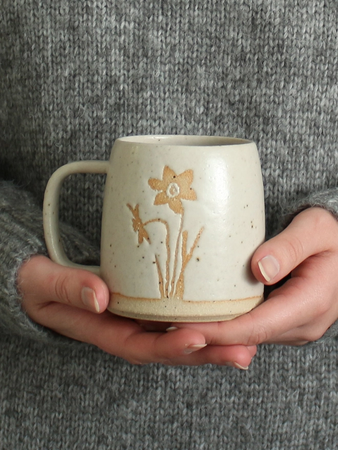 Hands holding Narcissus mug