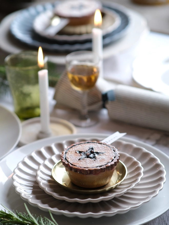A festive handpainted wooden mince pie place setting with handwriten note to welcome your guests at the Christmas table