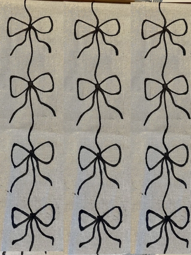 Hand Painted Bow Print Sustainable Linen Table Runner, a table runner with a black bow design. 