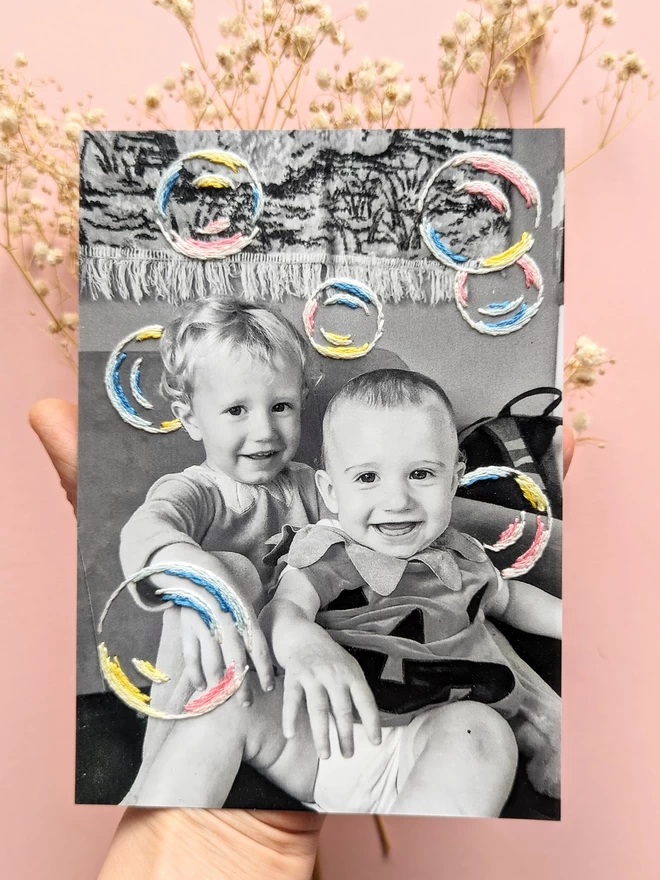 Black and white photograph of 2 children with hand embroidered bubbles 