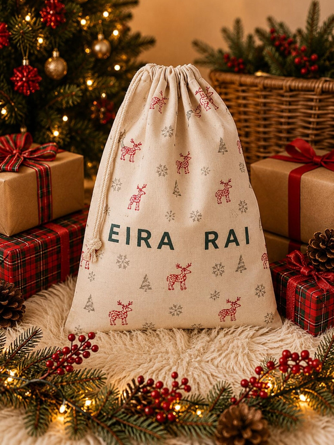 personalised drawstring christmas sack. a drawstring bag with printed christmas motifs and a personalised name.