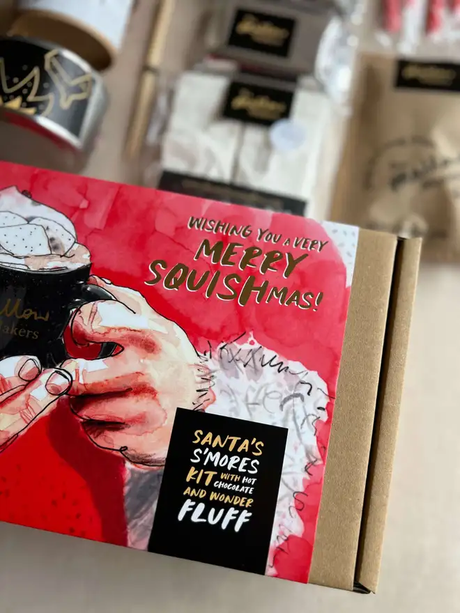 The-Mallow_Makers-close-up-of-santas-smores-kit-gift-box-with-contents-out-of-focus-behind