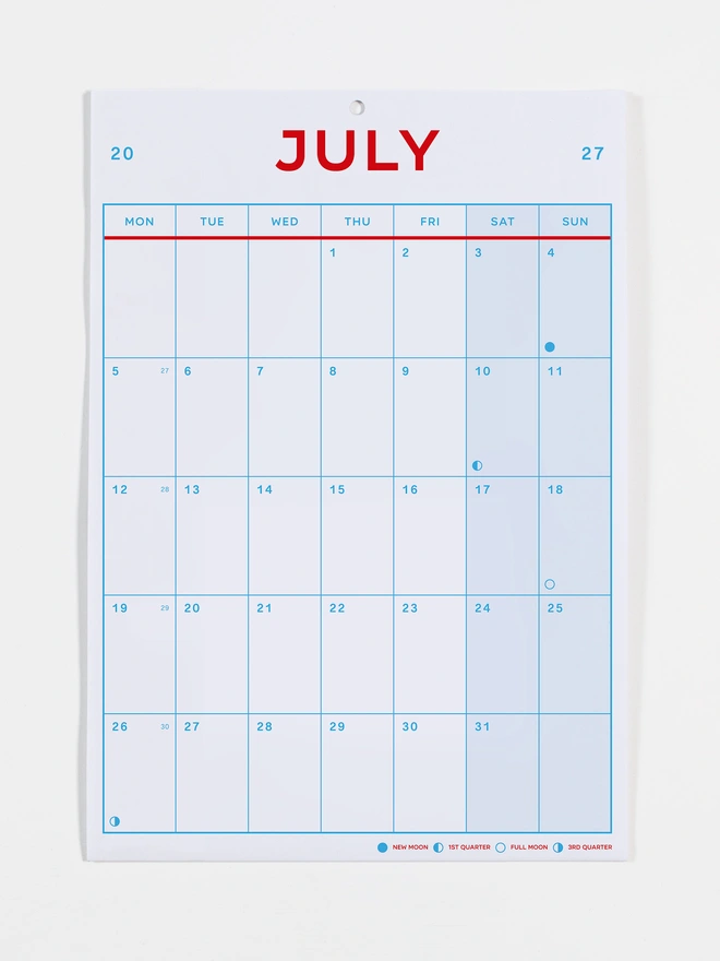 Monthly view calendar in red and blue on white recycled paper, photo shows the month of July