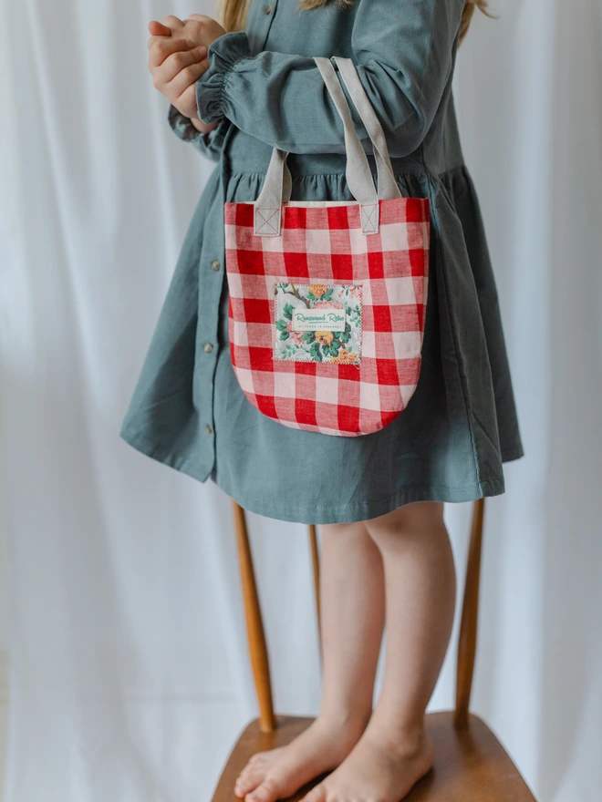 Girl holding her bag in red gingham